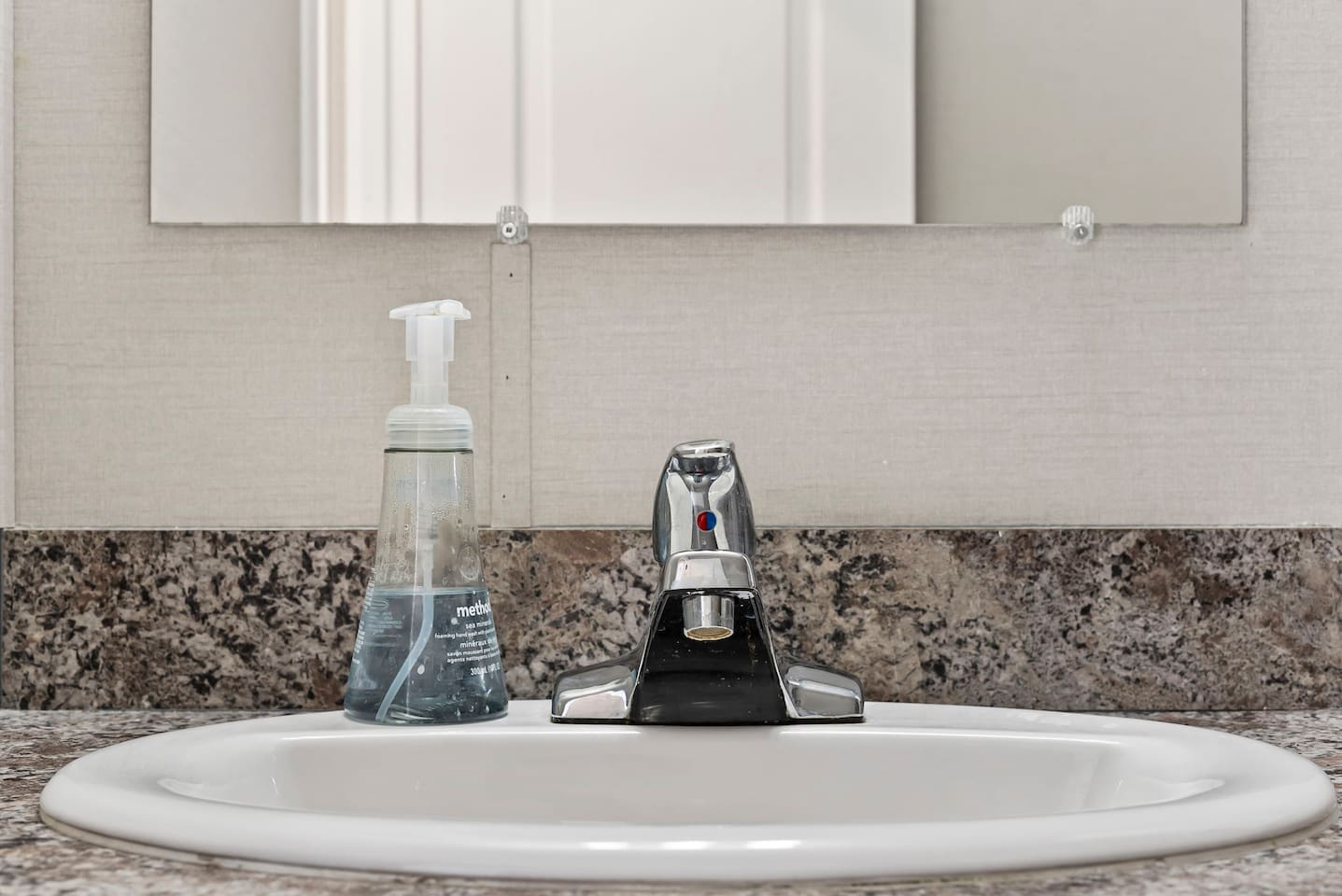 Vanity and sink area with sleek fixtures and convenient counter space for your daily essentials.