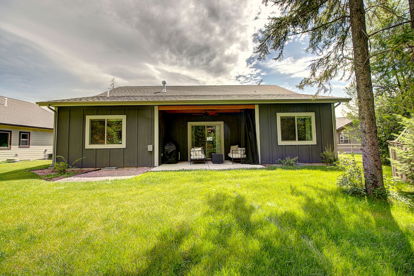 Relax on the covered patio overlooking a spacious, lush backyard—made for slowing down and soaking in the fresh air.