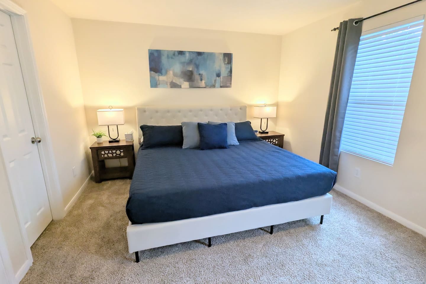 Oversized Primary suite includes a large walk-in closet, ceiling fan, cozy bedding, blackout curtains, a Roku TV, and dedicated workspace. 