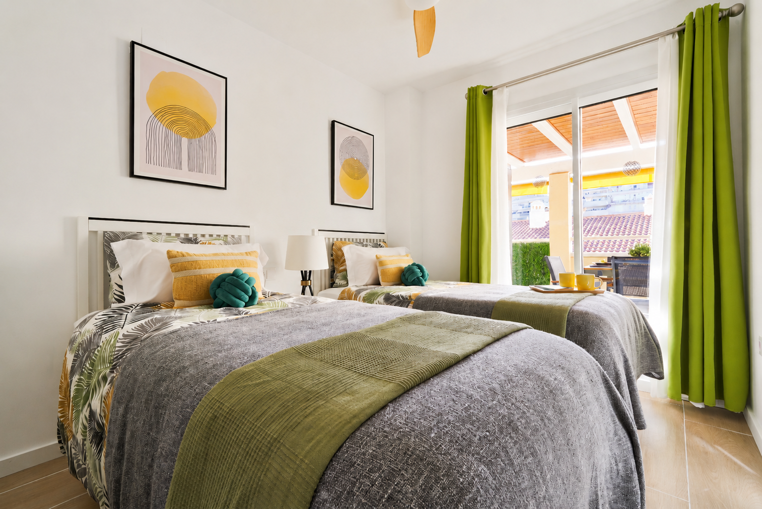 Bright and calming twin bedroom with tropical tones, soft linens, and direct access to the terrace — perfect for relaxed mornings and restful nights.