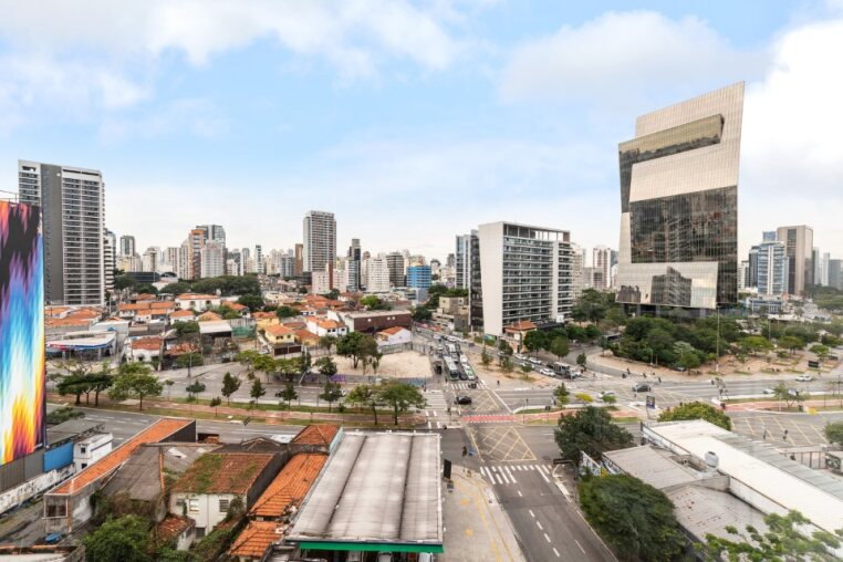 Vista lateral da varanda com skyline de Pinheiros Aprecie a cidade de São Paulo com conforto e elegância. Localização estratégica e vibrante.