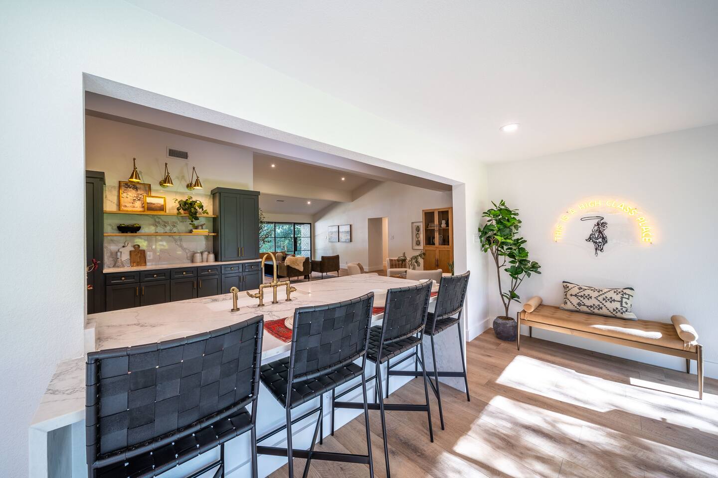 Breakfast bar with seating for four, showcasing natural light from large windows, and a seamless connection to the kitchen and living areas.