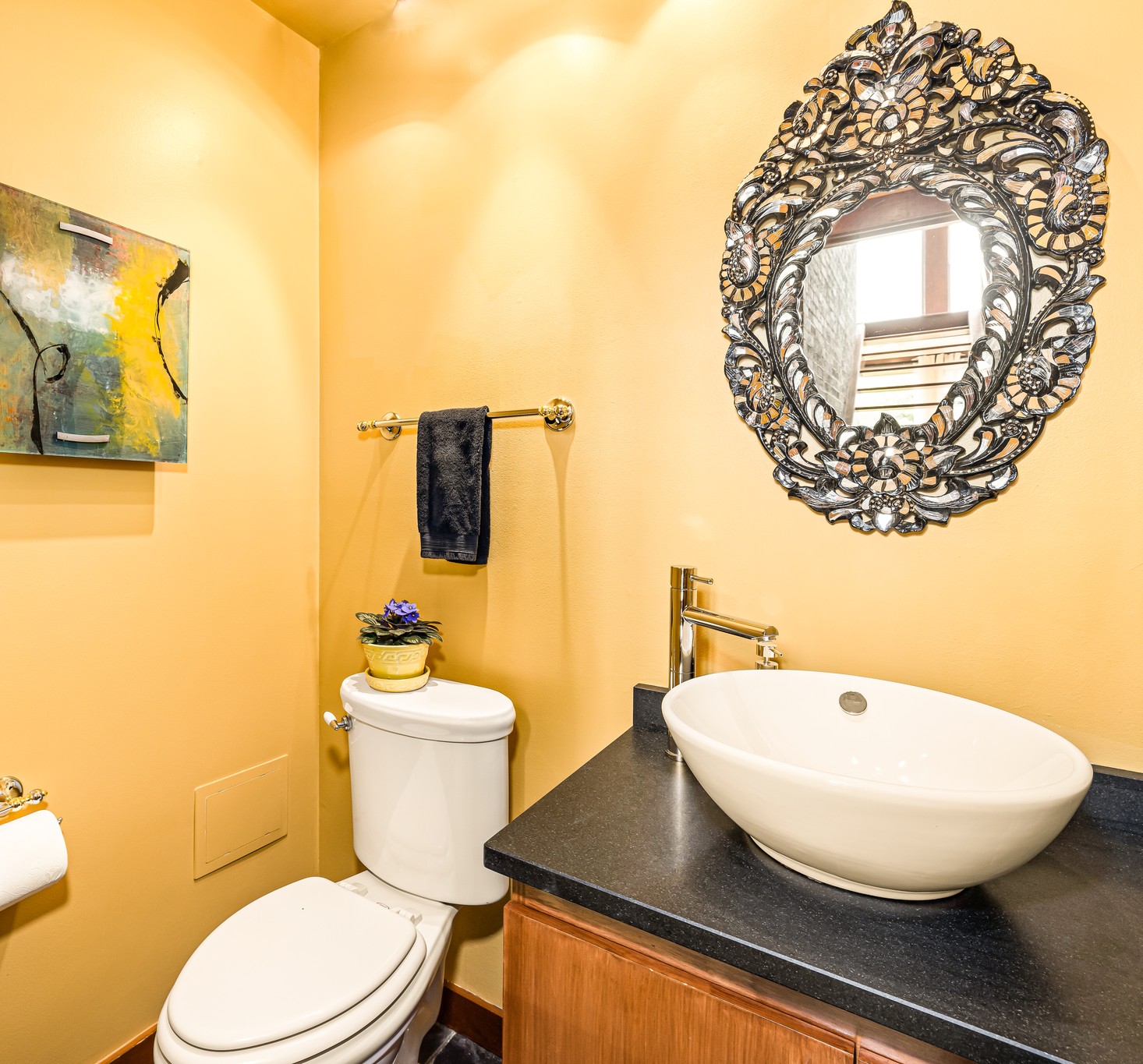 Main floor Powder Room is conveniently located off of the Great Room. The luxe stone counter, vessel sink, antique hand-cut glass mirror, and contemporary art add to Hilltop Oasis Abingdon's curated design experience.