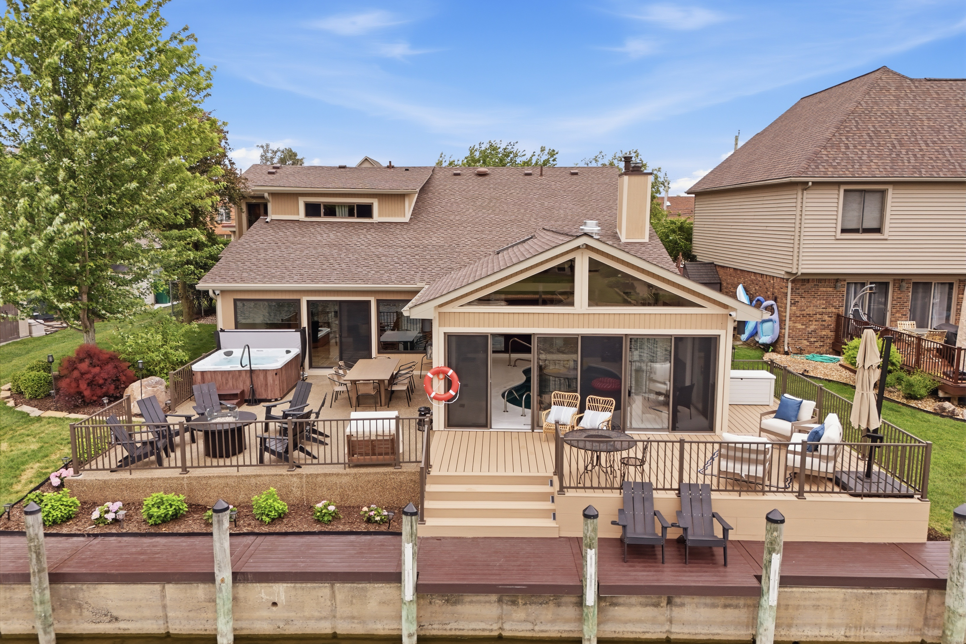 Spacious waterfront home with a large deck overlooking the canal. Features outdoor seating, dining area, and direct water access—perfect for relaxing, entertaining, and enjoying lakefront living.