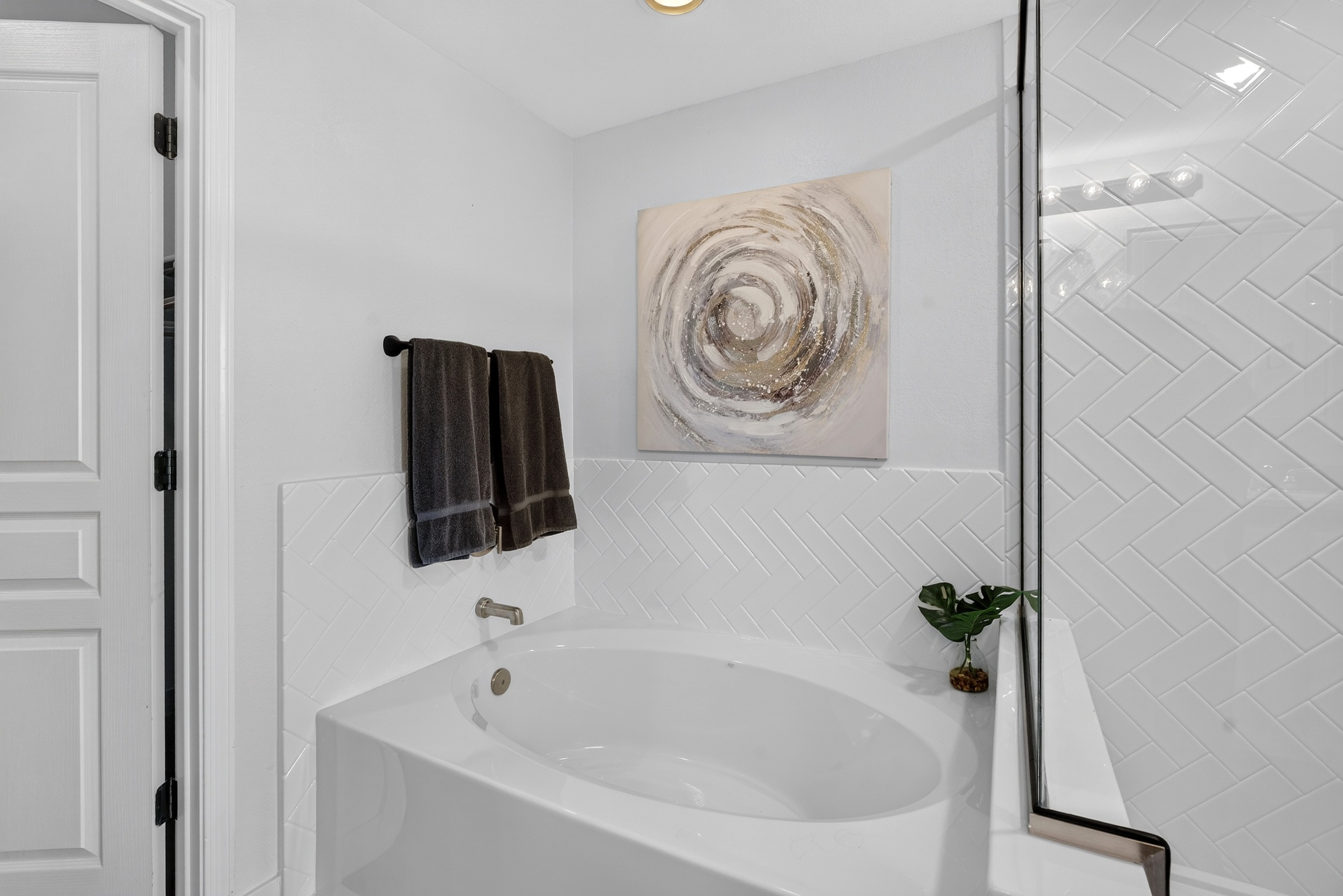 Bathroom with vanity storage, walk-in shower, soaking tub, and clean updated finishes for daily routines.