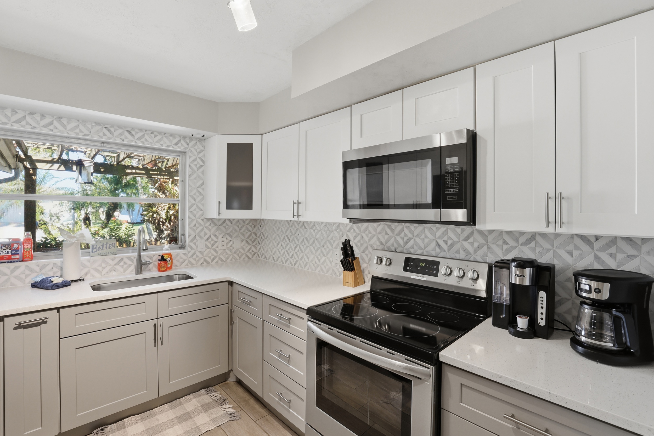 Fully renovated & stocked kitchen with quartz and stainless steel appliances.