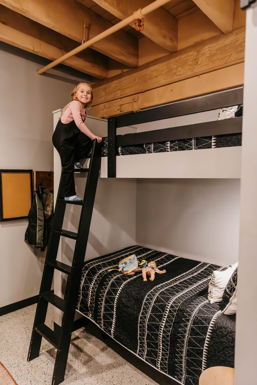 Child climbing the ladder to the top bunk in a Brix condo bunk room