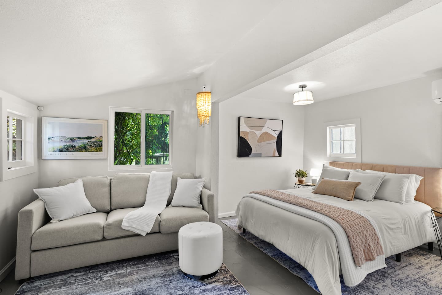 Cozy studio living space with modern decor, natural light, comfortable seating, and a Smart TV for relaxing stays. There is also a sofa bed that pull out into a queen bed. 