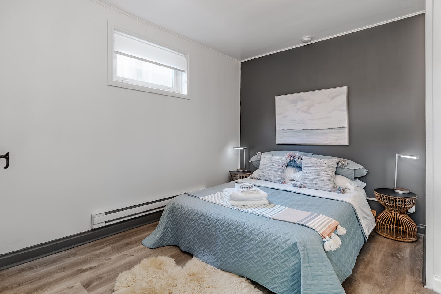 Comfortable basement bedroom with queen bed and soft lighting