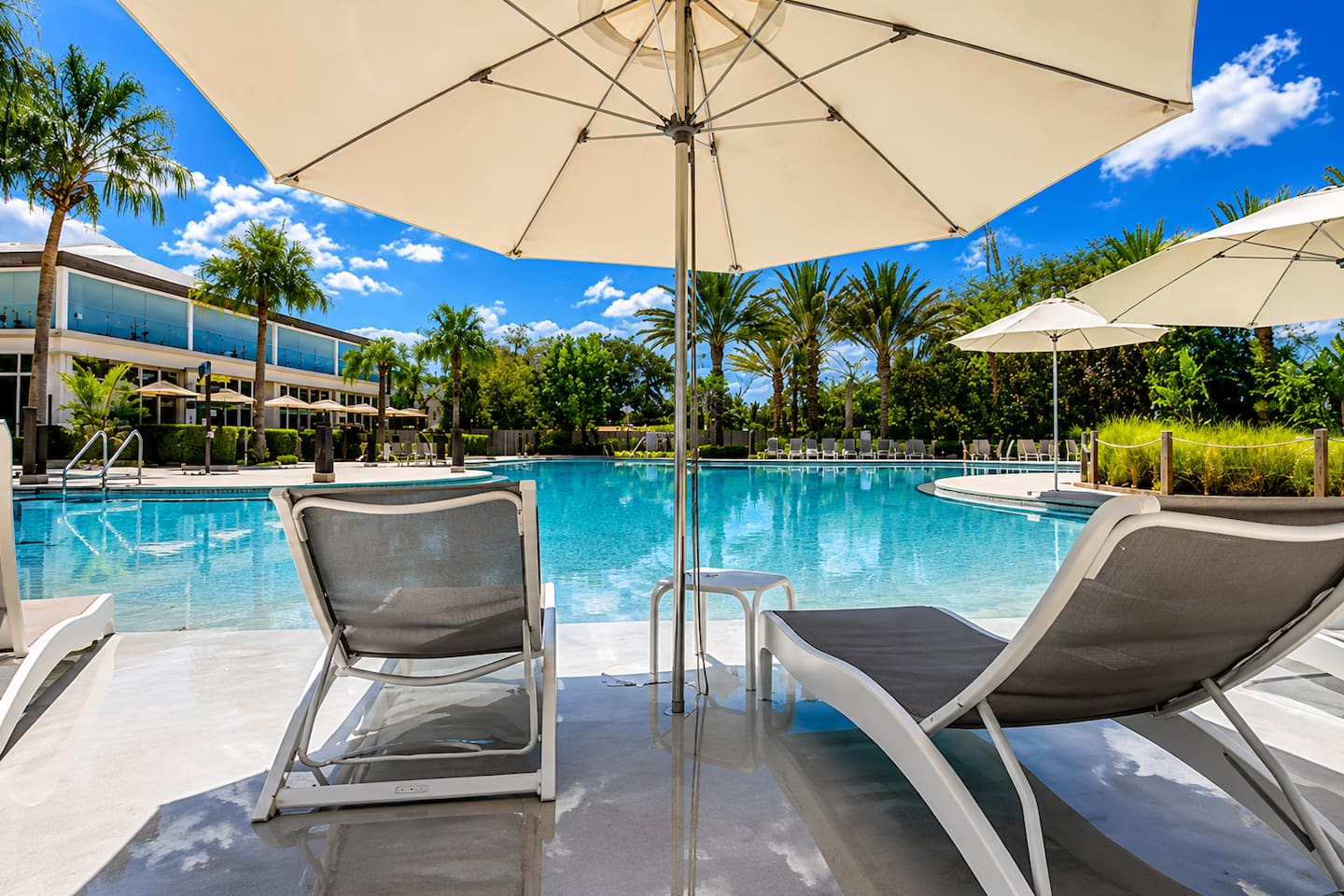 Unwind in style under the Florida sun. Comfortable loungers + umbrellas right by the resort pool.