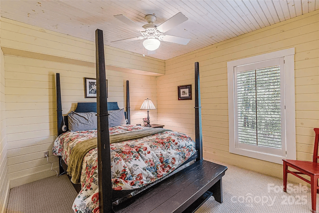 Charming Bedroom: Unwind in a four-poster bed adorned with vibrant floral decor and warm light!