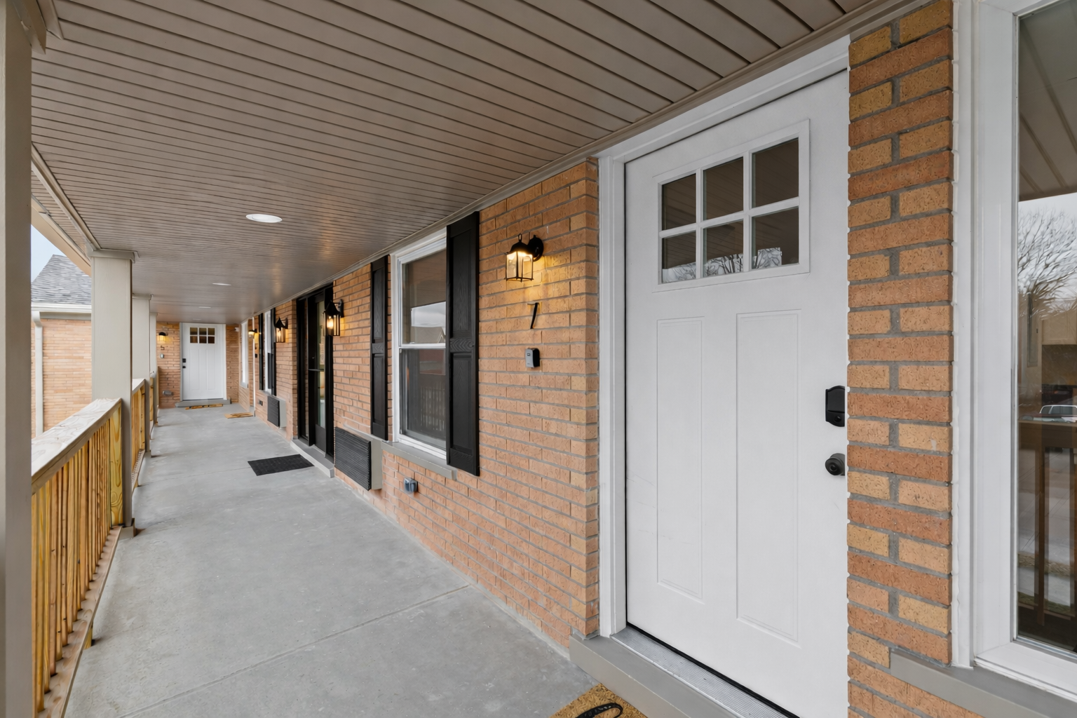Private covered entry with classic brick details, soft exterior lighting, and an easy-access walkway—creating a warm, secure arrival experience.