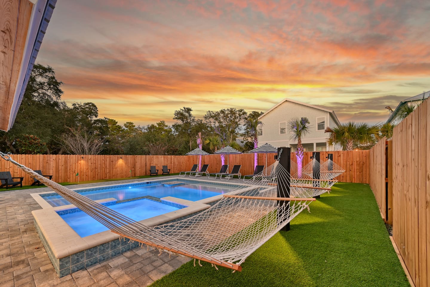 Landscape lighting at sunset and poolside hammocks