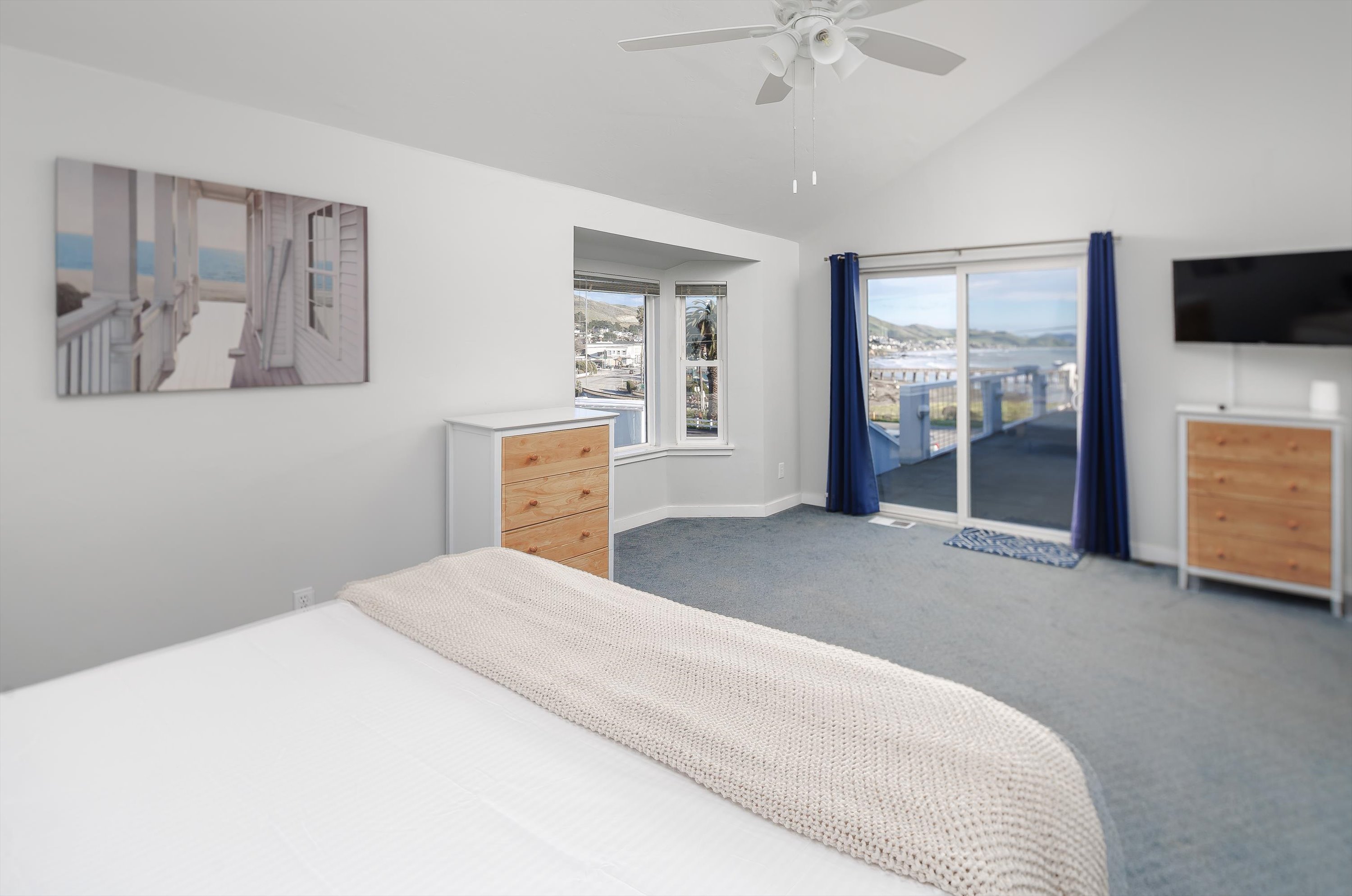 A spacious, bright bedroom designed to make everyone smile — with a big glass slider overlooking the ocean.