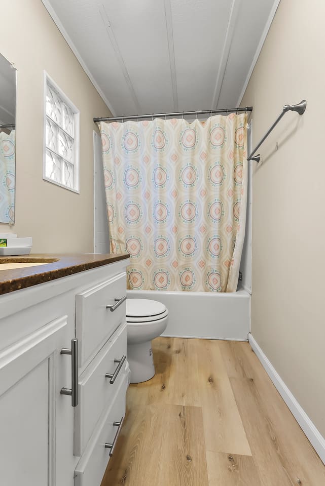 Spacious layout with wood-style flooring and a clean, modern vanity.