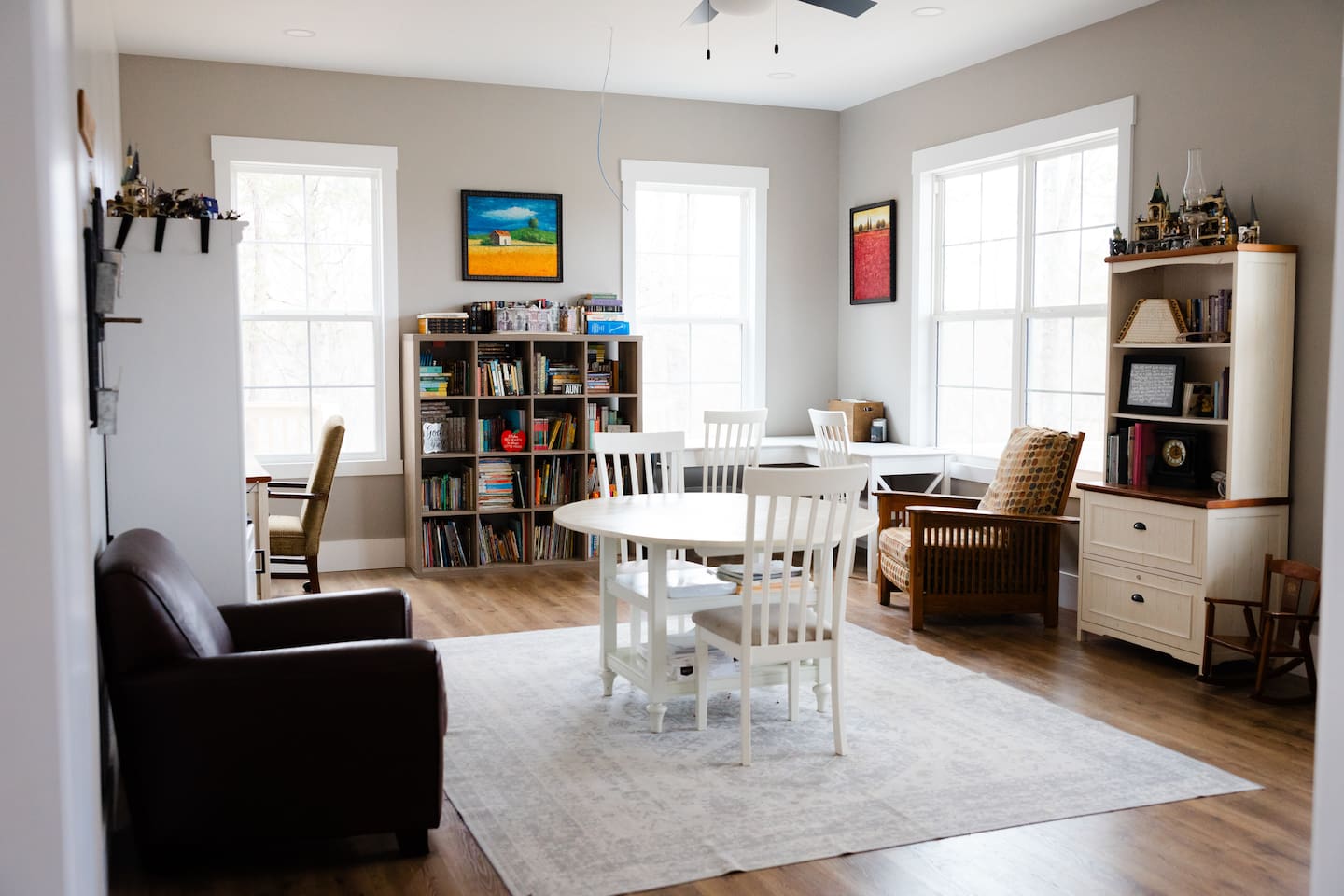 Our library features three work spaces, two comfy chairs for reading, PLENTY of books (we love the classics!), children's art supplies & crafts, as well as a piano and a few guitars. Beautiful views from these windows too. Open to living room/foyer.