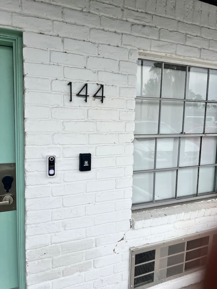 Entry detail with doorbell camera and Brinks access panel beside the front door.
