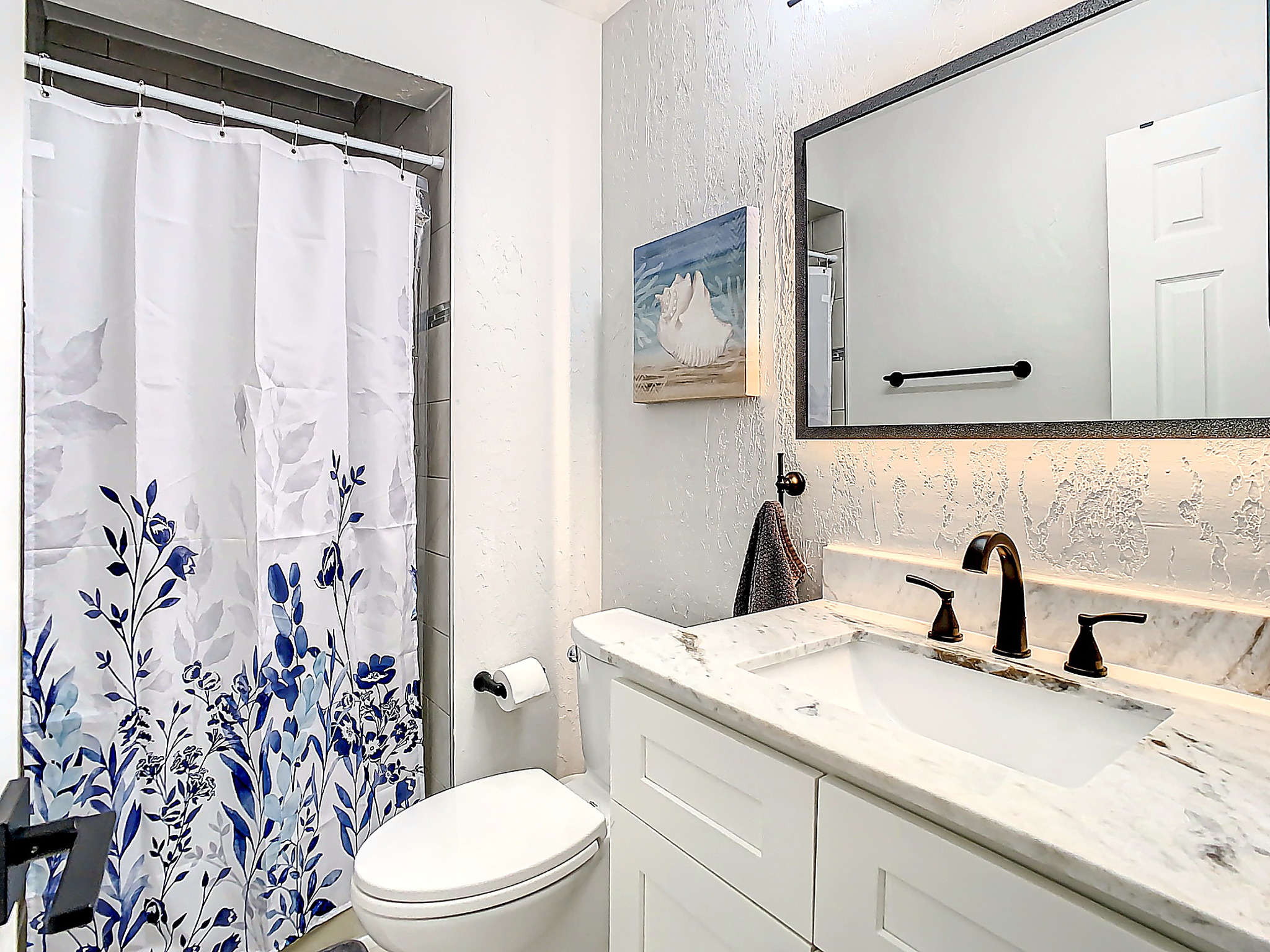 Elegant bathroom featuring modern vanity with sink, large mirror, and neutral color scheme for a spa-like experience.