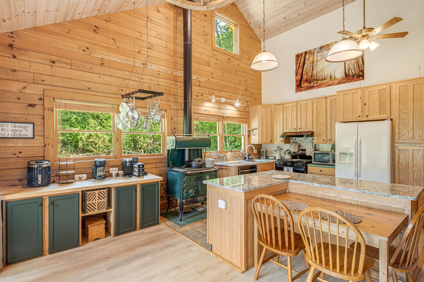 Start your day in this charming mountain kitchen, where rustic wood tones and natural light create a warm, inviting space with an abundance of cookware and dinner wear.