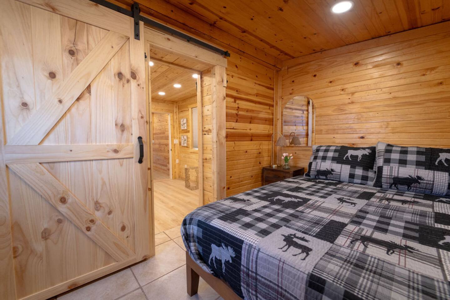 Step into this cozy little hideaway, just a step up from the living room and tucked behind a rustic barn door. With warm T&G walls, a comfy queen bed, blackout shades, and a private door to the backyard, it’s your dreamy escape!