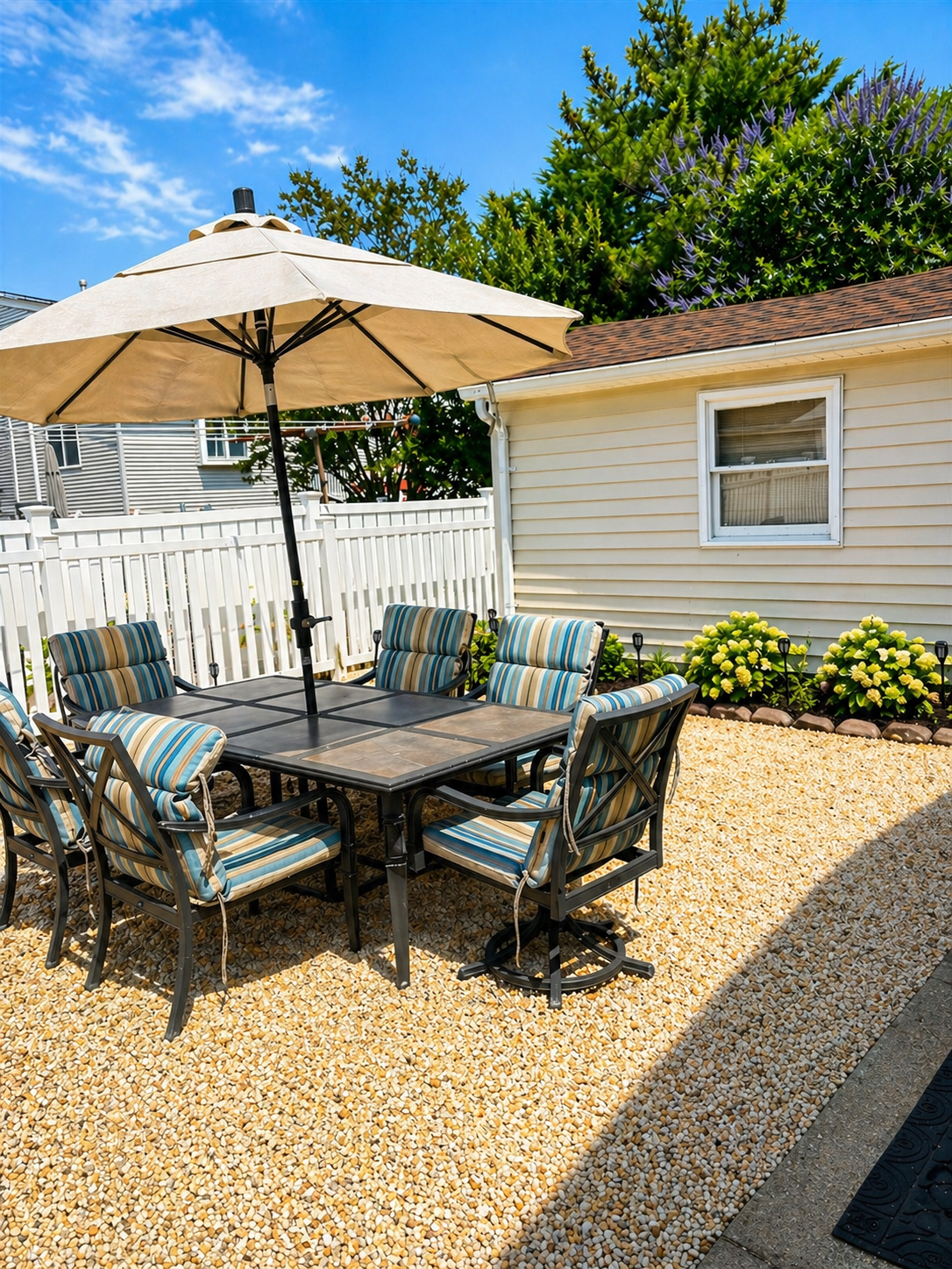 Spacious backyard featuring plenty of outdoor furniture, a hammock, gas grill, clothesline, and outdoor showers.