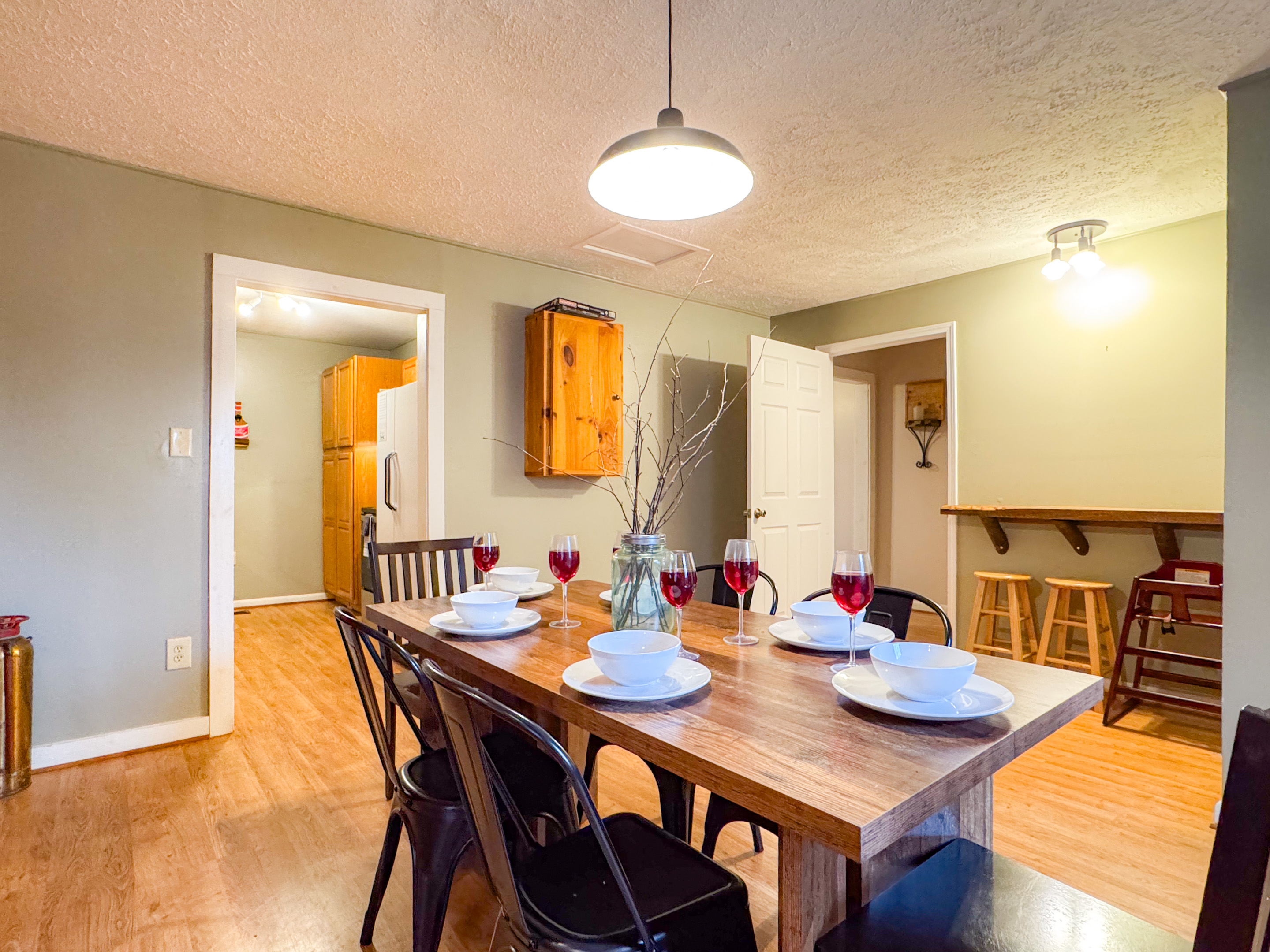 dining room area complete with seating for 6 at the table and a small bar top for 2 additional
