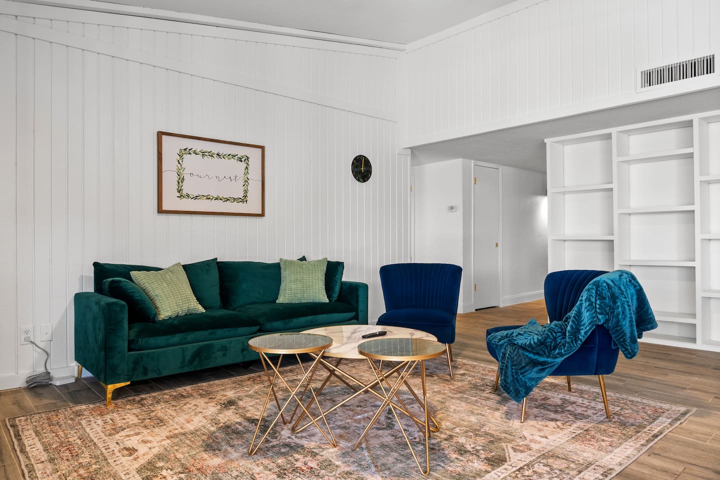  Spacious open-concept living area with a sleek green sofa, elegant decor, and direct flow into the modern kitchen.