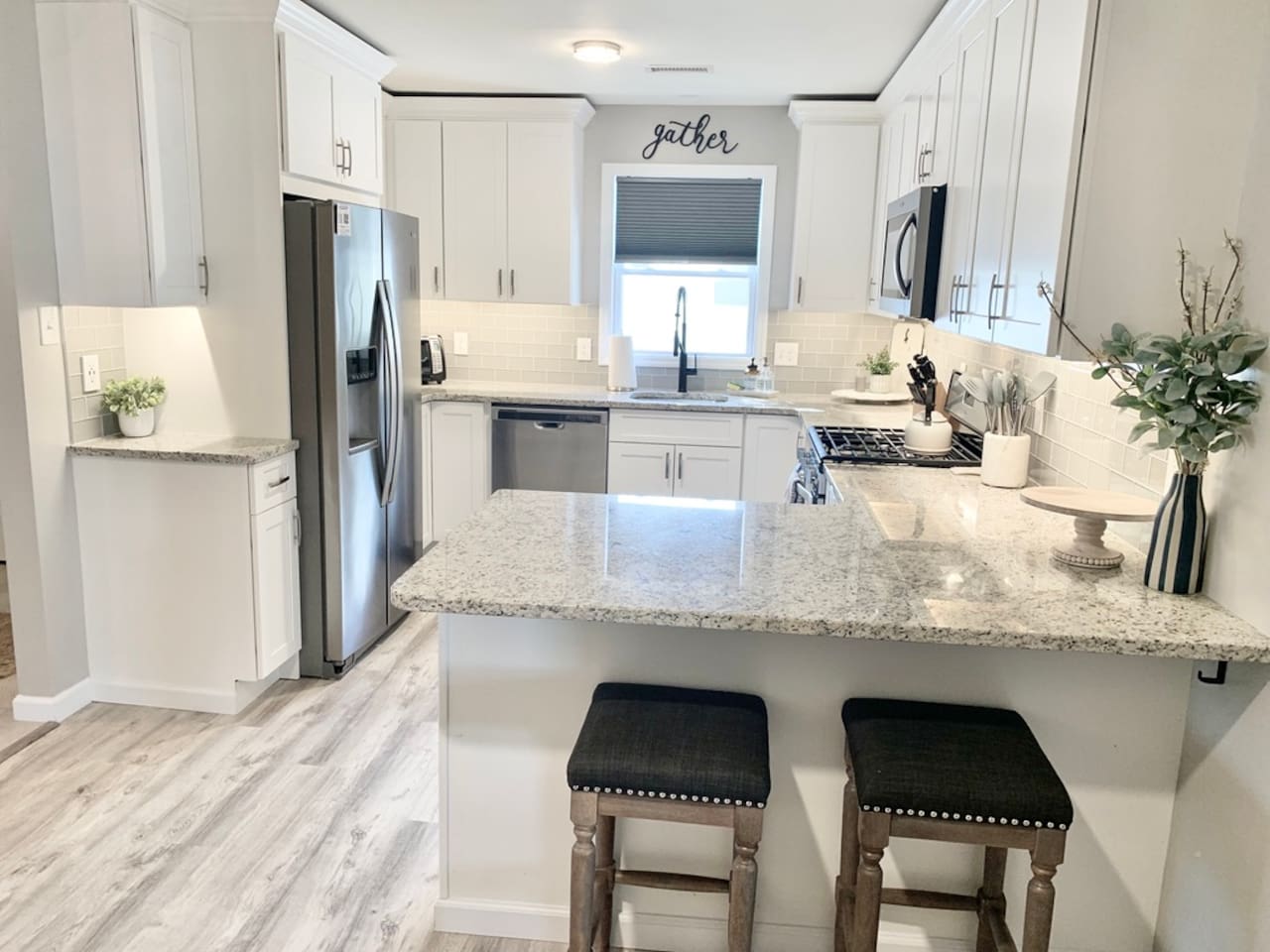 Cook with style in this bright, updated kitchen featuring stainless steel appliances and white cabinetry. The expansive granite countertops and breakfast bar seating make it a perfect spot for morning coffee or casual meal prep.