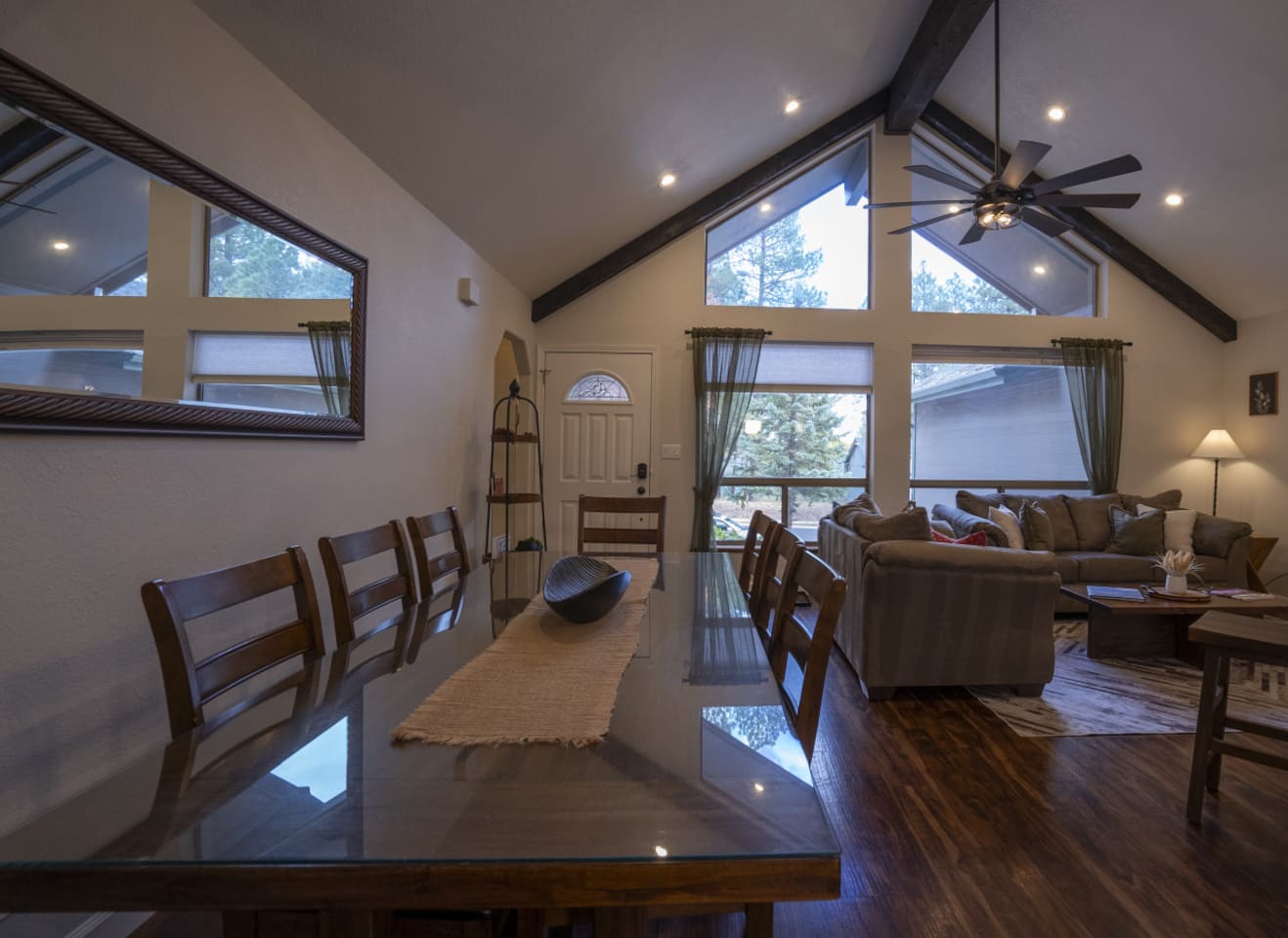 Dining and living area with high ceilings, wood floors, and a comfortable layout for gathering.