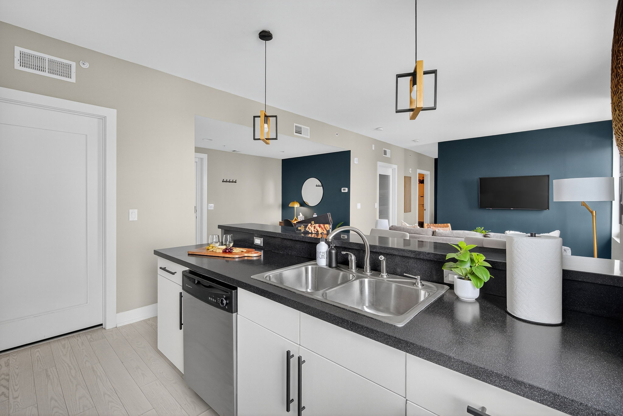 Sleek and functional kitchen island featuring a double sink, modern fixtures, and a view into the open-concept living space.