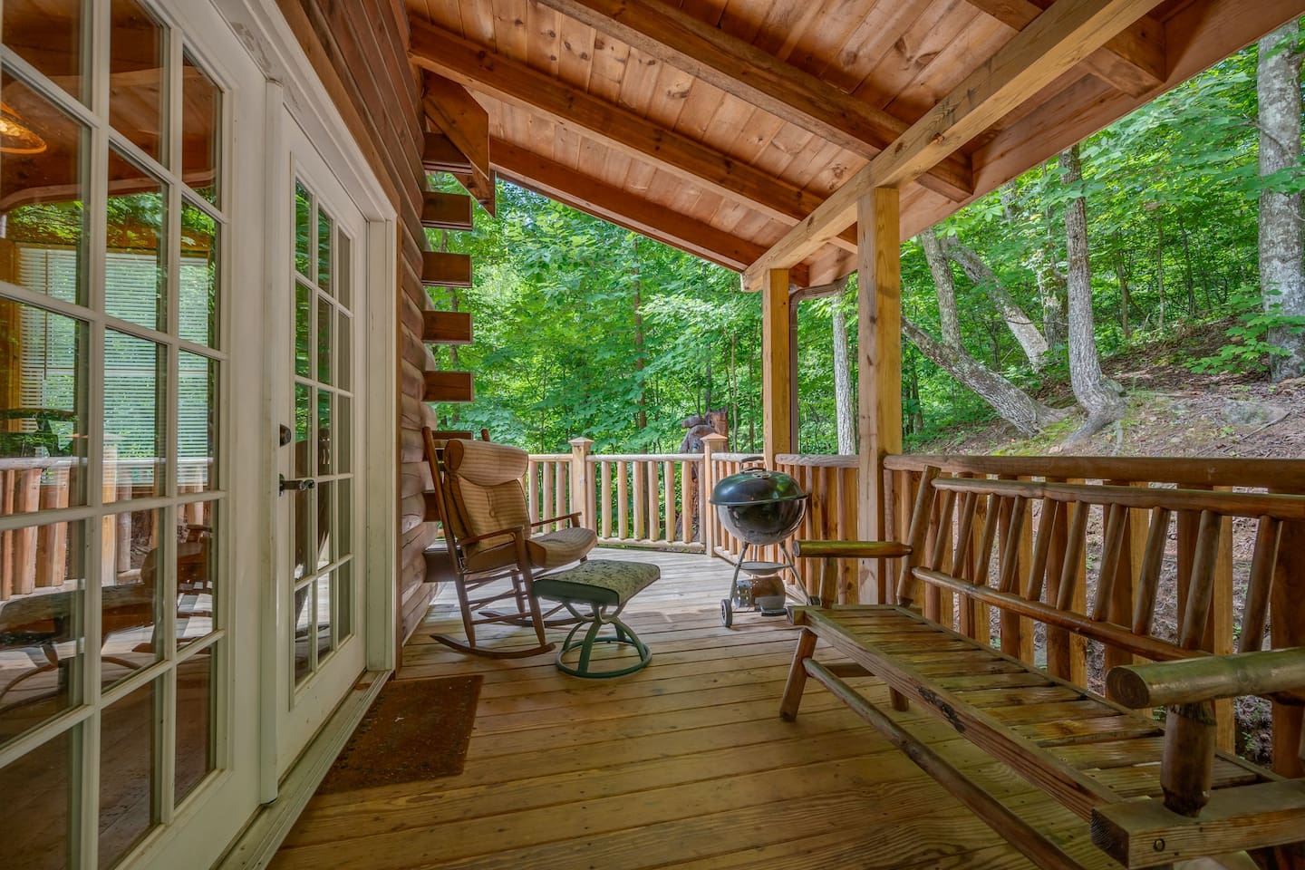 Back deck with large hand made log picnic table, corn hole games and grill