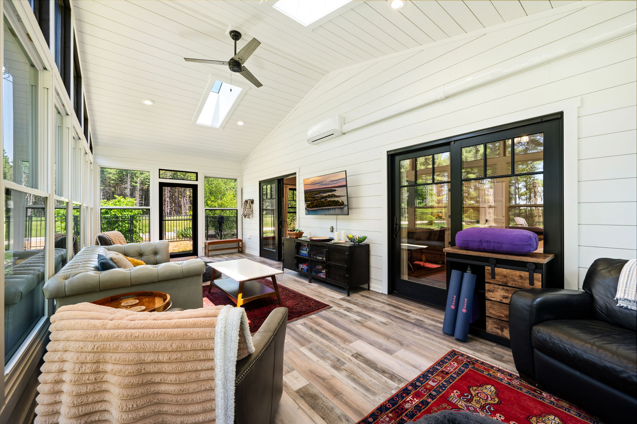 Stretch, stream, or simply relax in the versatile sunroom, complete with yoga mats and bolster, a smart-TV, and sweeping forest views.