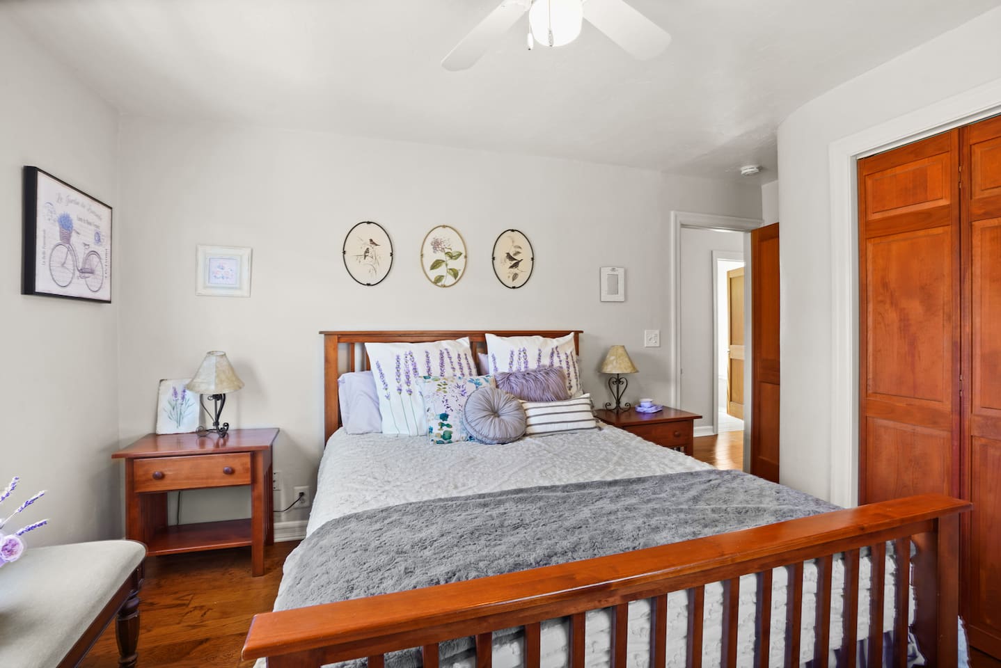 Bright and charming lavender guest bedroom with a queen bed and closet for easy storage.