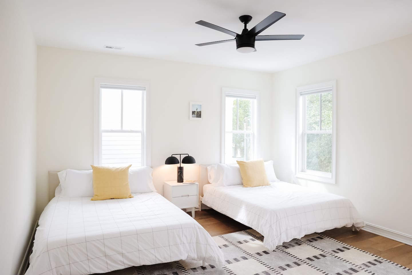 The spacious "sunrider room" features two queen beds, a spacious double-door closet, a full bath with a shower, smart TV and coastal photography. 
