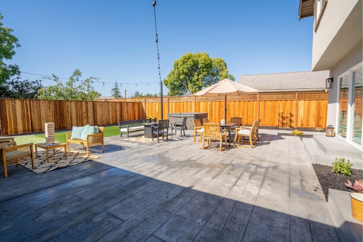 Backyard with hot tub, outdoor dining and seating with fire pit.