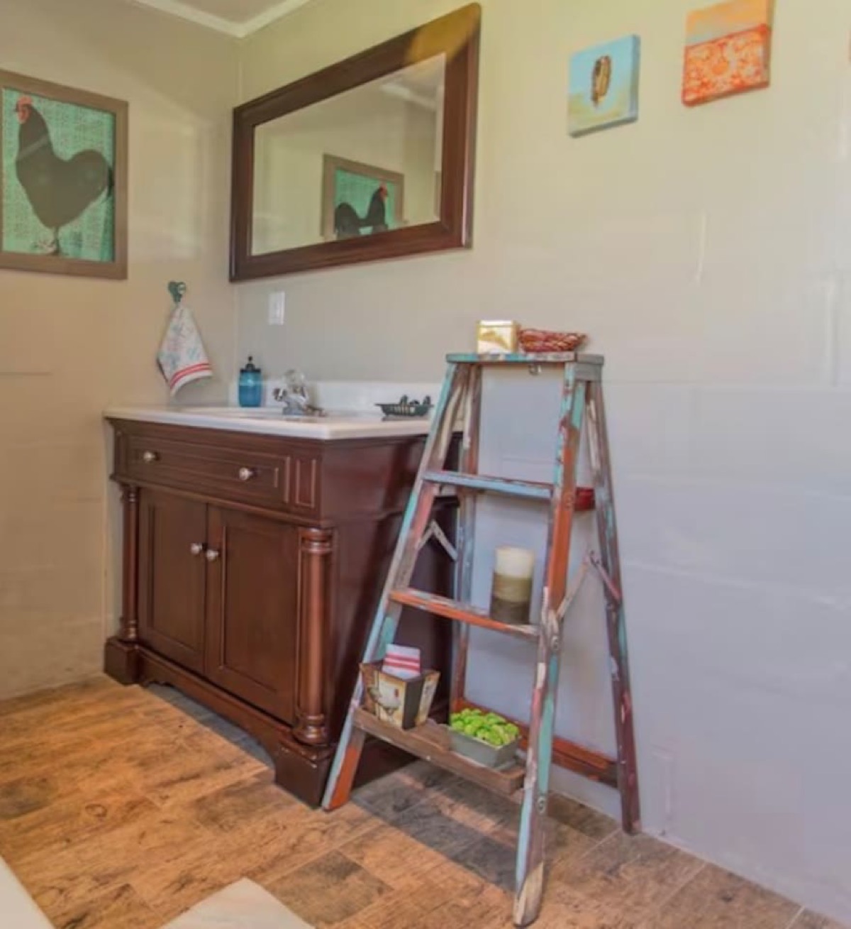 Artist-designed bath with wood vanity, framed mirror, and curated decor. Warm, stylish, and full of character.