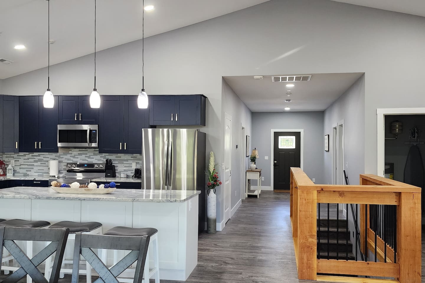 Modern, fully equipped kitchen with large island seating and open flow to entry and living spaces—perfect for cooking and gathering together.