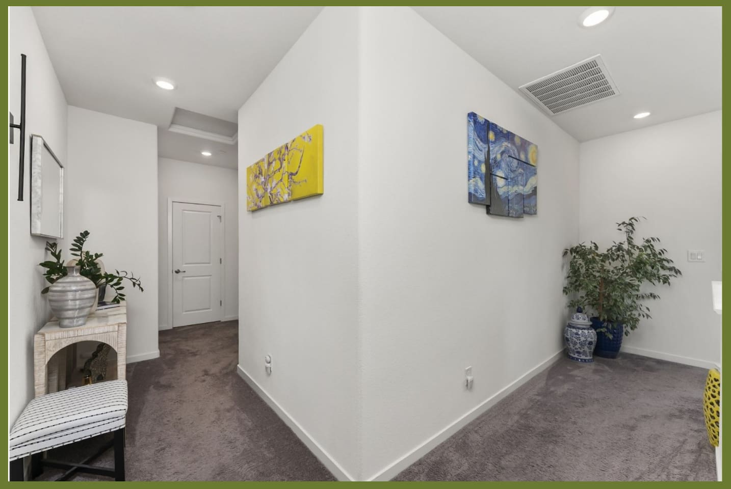 Upstairs hallway with soft carpeting, decorative wall art, and clean access between bedrooms and nearby rooms.