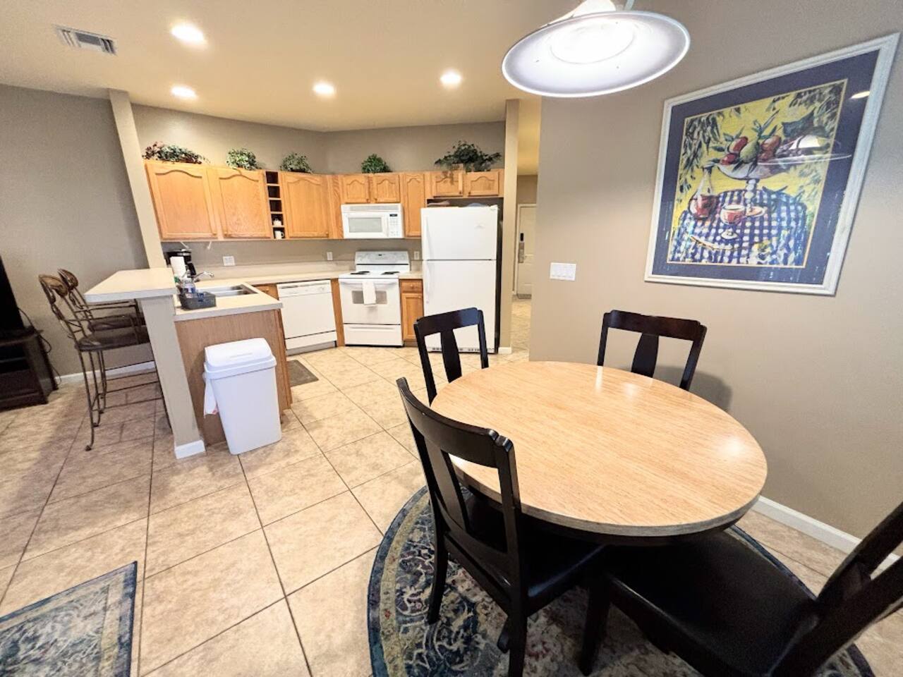 Open dining and kitchen area featuring a round dining table, breakfast bar seating, and a fully equipped kitchen.