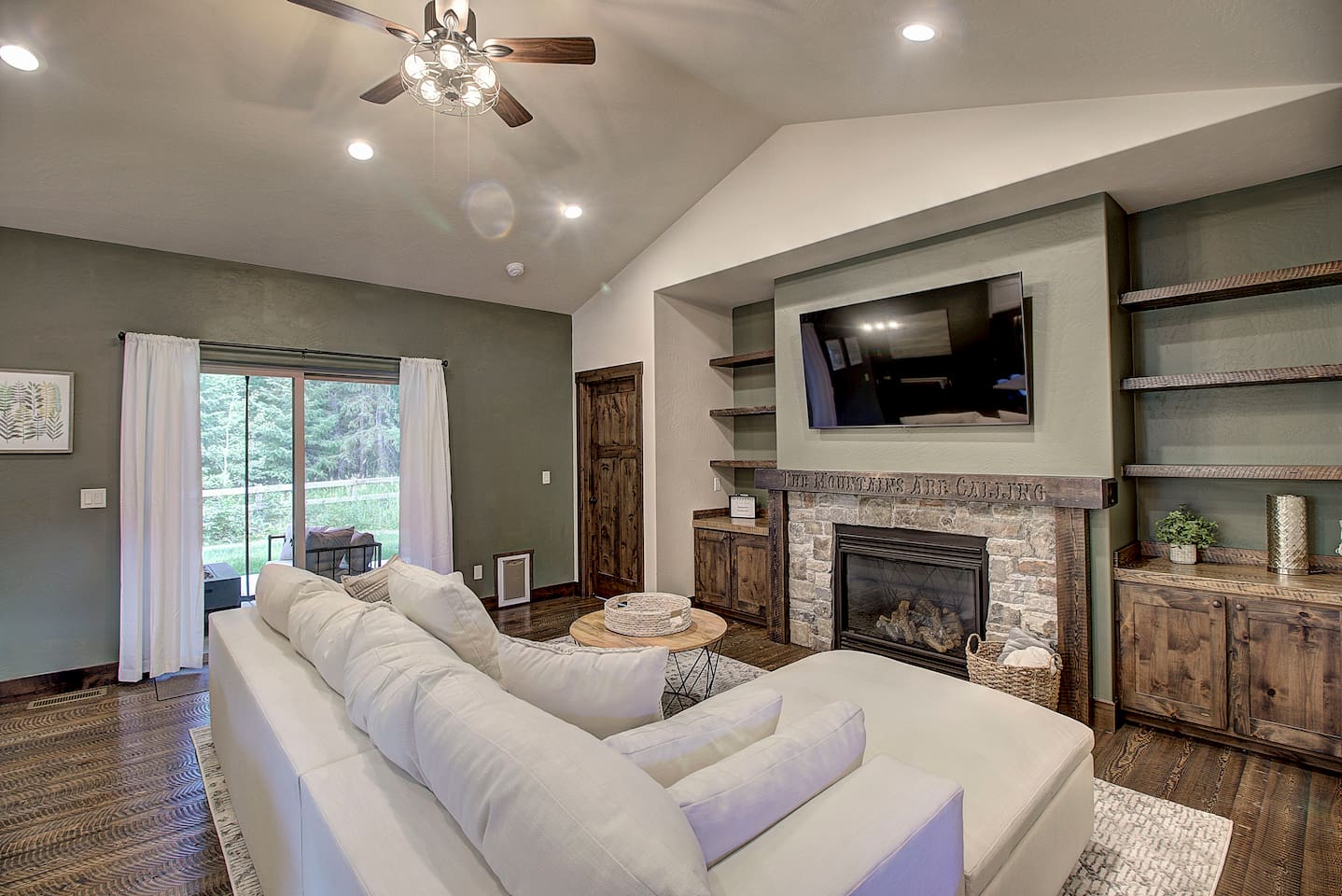 Bright living space with sliding doors leading to the backyard and serene forest views.