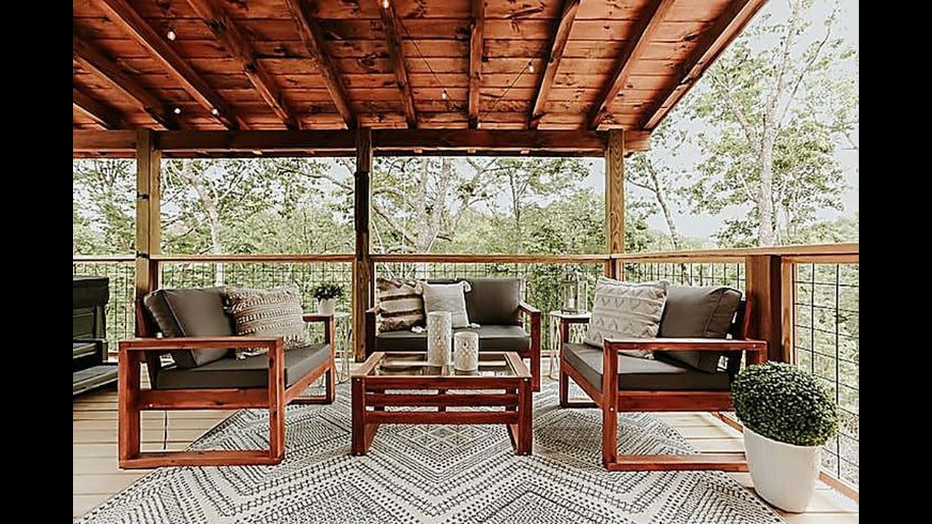 Settle into this dreamy covered deck—complete with comfy seating, string lights, and the calming sounds of the woods