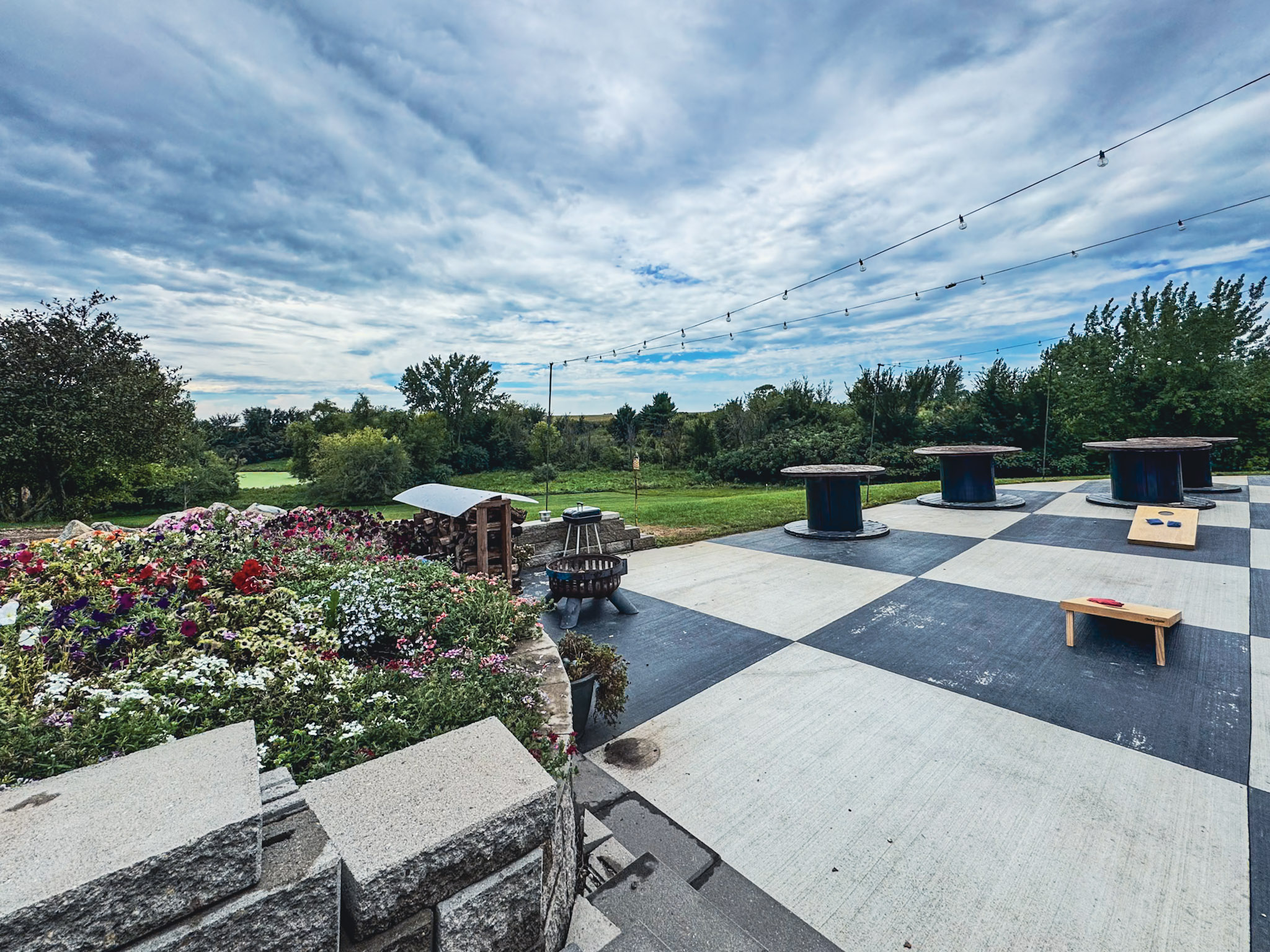 Spacious patio with cornhole, string lights, and countryside views.