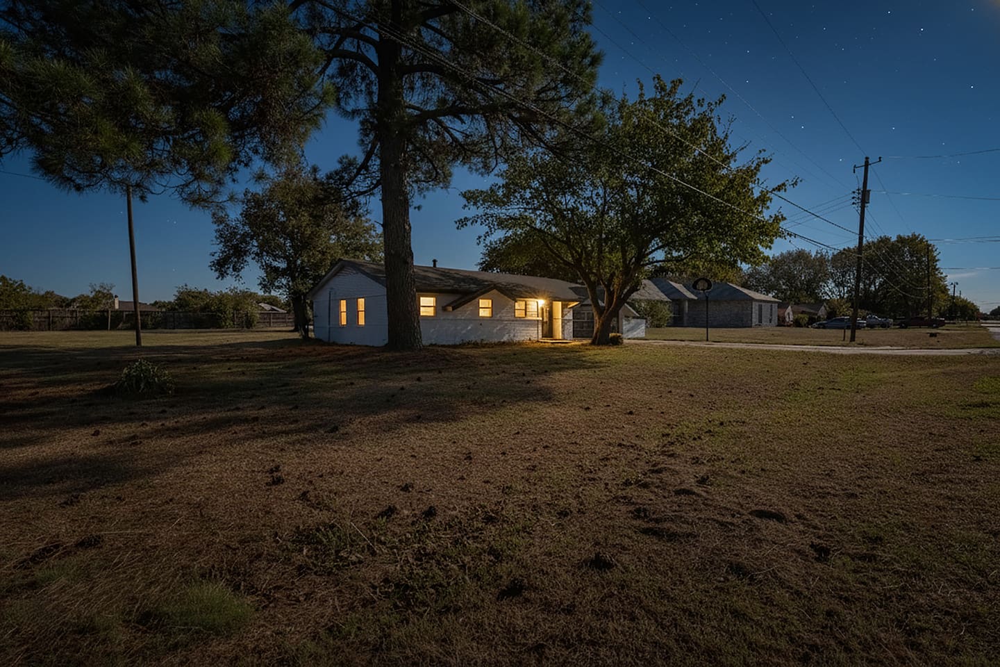 Dusk exterior of our Grand Prairie retreat. This 3-bed, 2-bath home sleeps 6 and features a spacious yard for kids or pets to play, plus plenty of parking for your group.