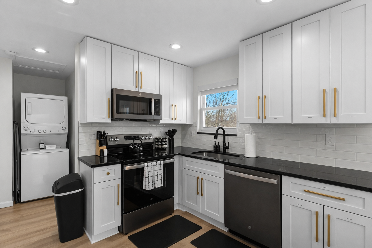 Fresh, stylish kitchen with white cabinetry, sleek black appliances, and plenty of counter space—bright, functional, and fully stocked for everyday cooking.