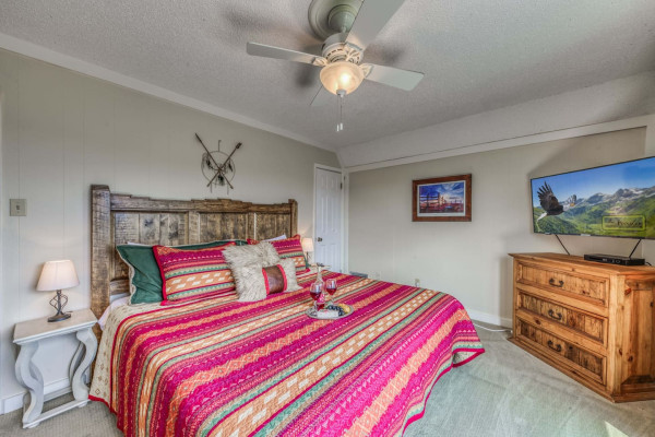 Relax in the cozy bedroom featuring a comfortable king-sized bed and a TV for your entertainment, the perfect spot to unwind after a day of exploring.