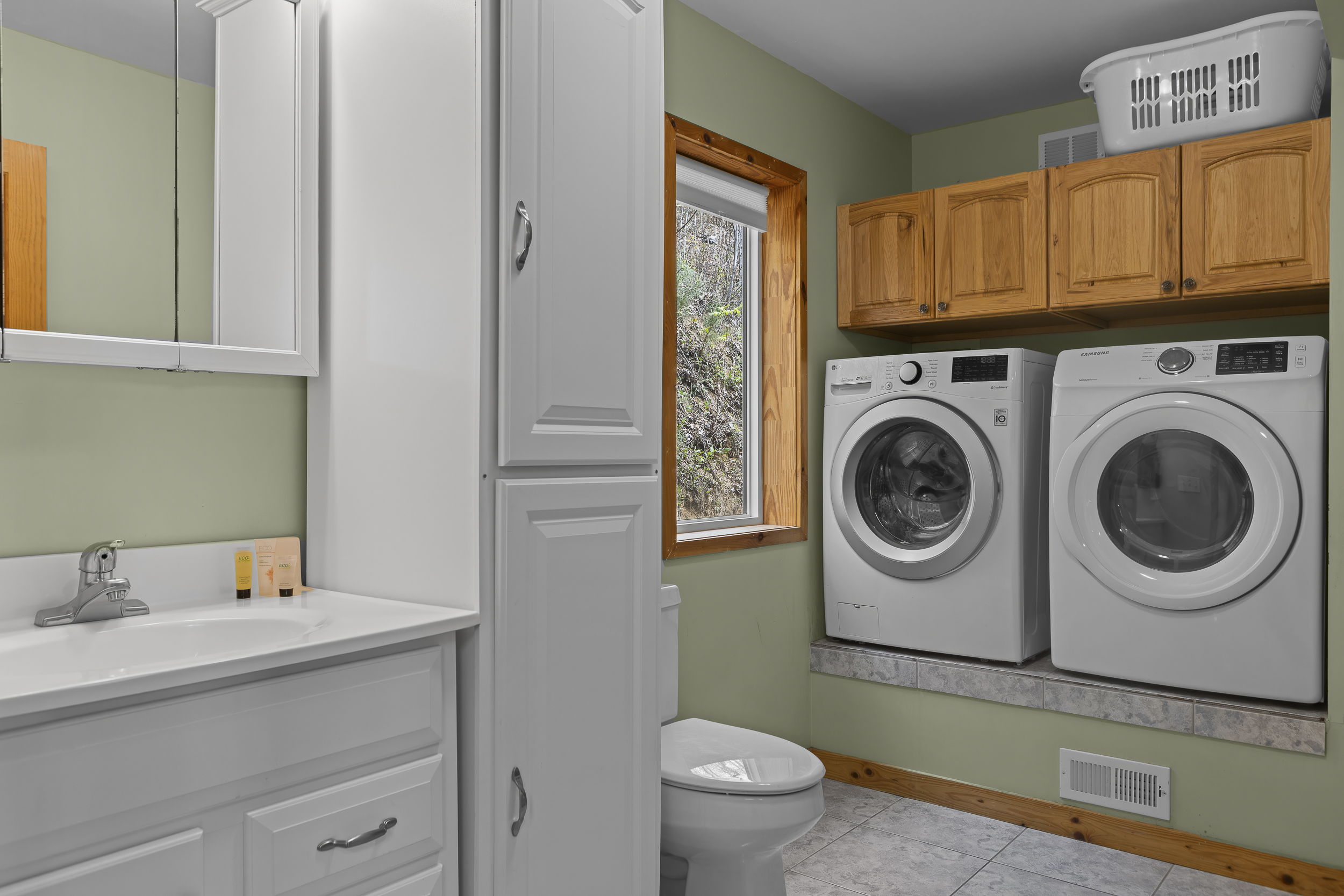 Laundry Room/Half Bath: Bright and functional space with modern appliances and serene greenery views!