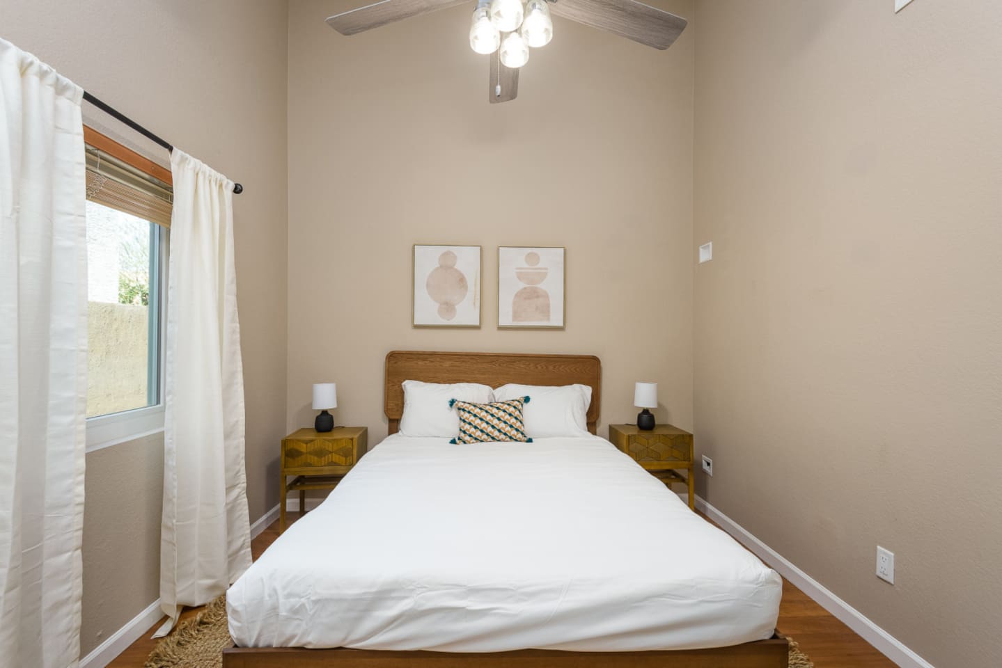 Guest Bedroom 2 with a queen bed, ceiling fan, bedside tables, and a calm setup for a comfortable stay.