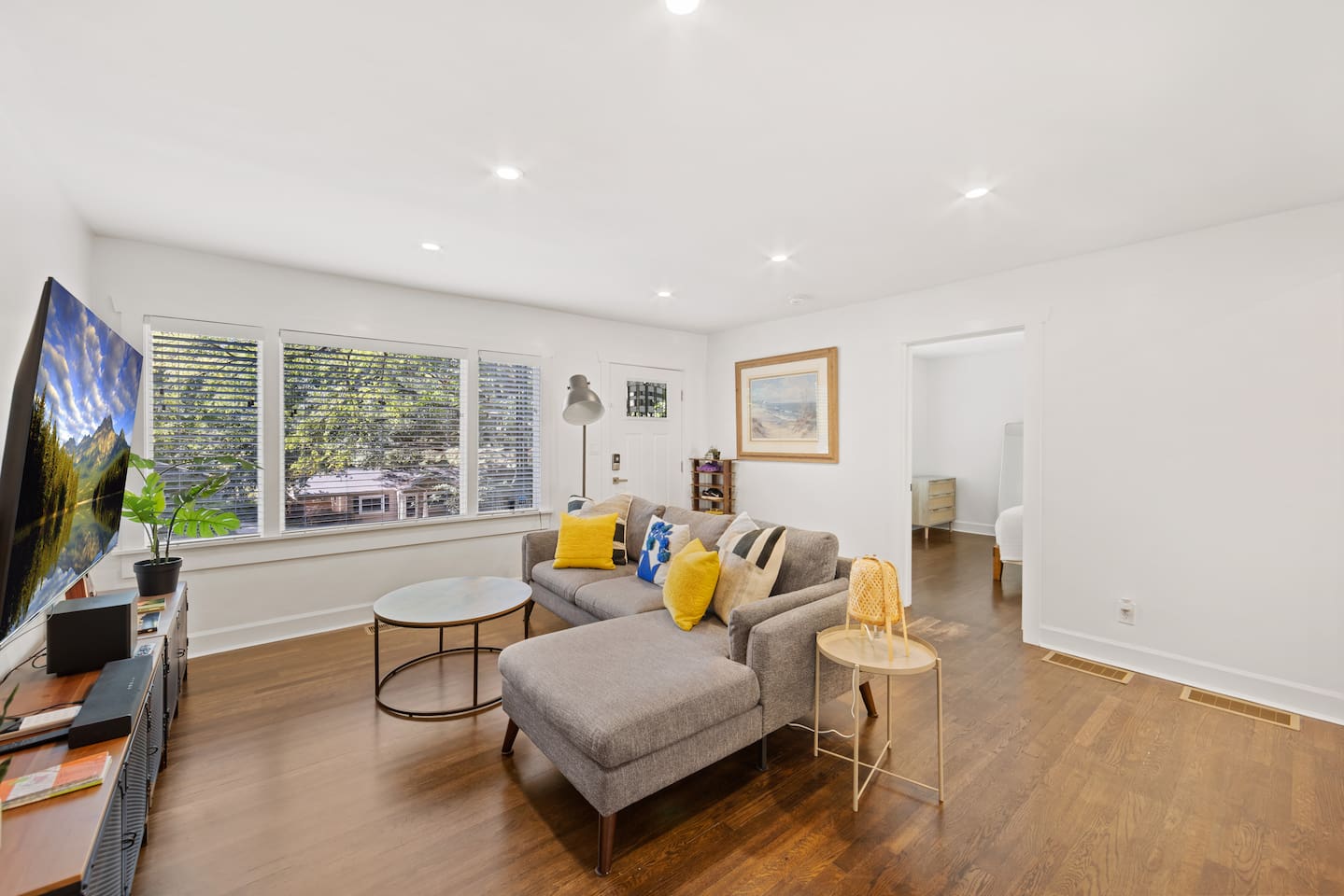 Living room with front bedroom in the background.  Original hardwood floors are refinished with natural water-based coating.