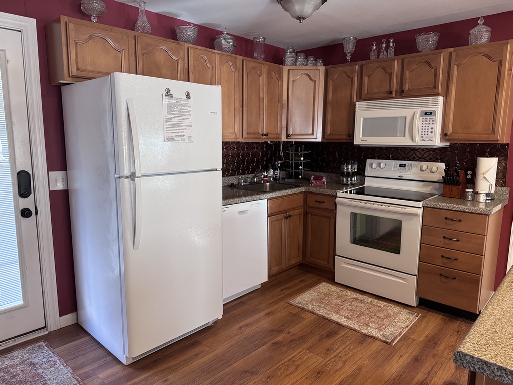 The kitchen has a refrigerator, oven, microwave, dishwasher, and under-cabinet lighting.