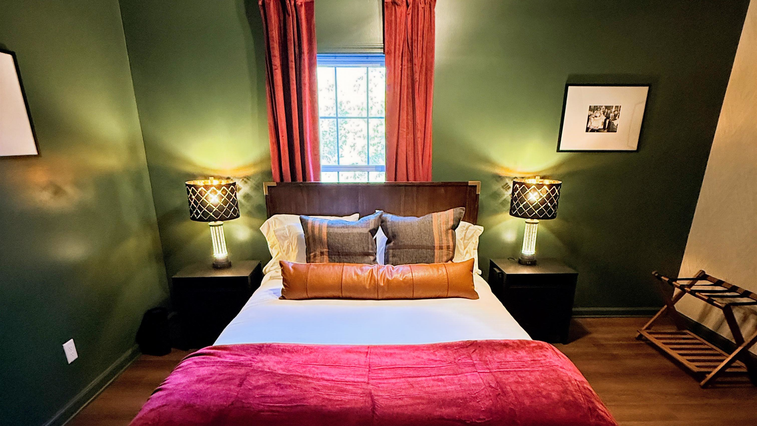 Rich green walls and amber lighting set the stage for restful nights and unhurried mornings — a cozy hideaway that feels both intimate and effortlessly stylish, echoing the quiet elegance of bourbon-country living.